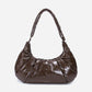 A glossy texture Croissant-shaped shoulder bag in glossy brown color by Dude & Bestie