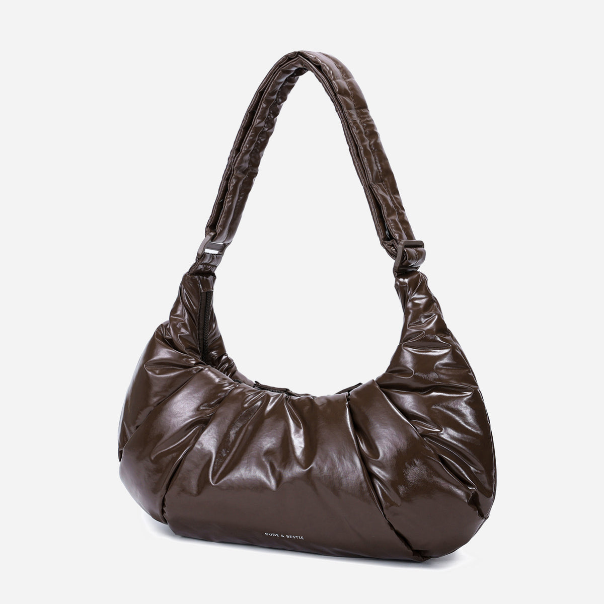 A glossy texture Croissant-shaped shoulder bag in glossy brown color by Dude & Bestie