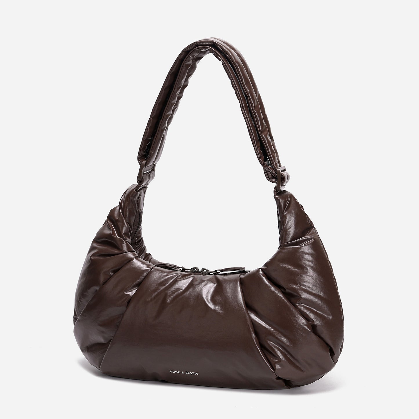A dark brown shiny Croissant-shaped shoulder bag in polish brown color by Dude & Bestie